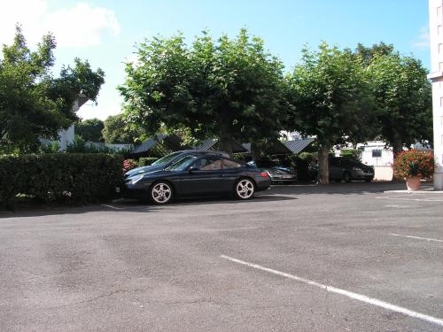 a black car parked in a parking lot at Hotel de La Paix in Oloron-Sainte-Marie