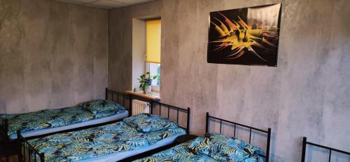 Pokój z dwoma łóżkami i zdjęciem na ścianie w obiekcie Zaciszne pokoje w Warszawie