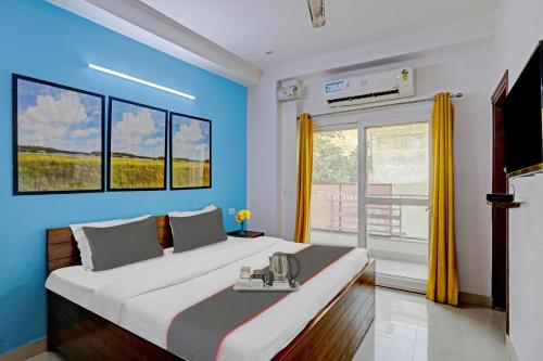 een slaapkamer met een groot bed met blauwe muren bij Collection O Hotel Daffodils in Gurgaon