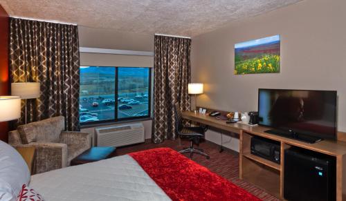 a hotel room with a bed and a desk and a television at Shoshone Rose Casino & Hotel in Lander