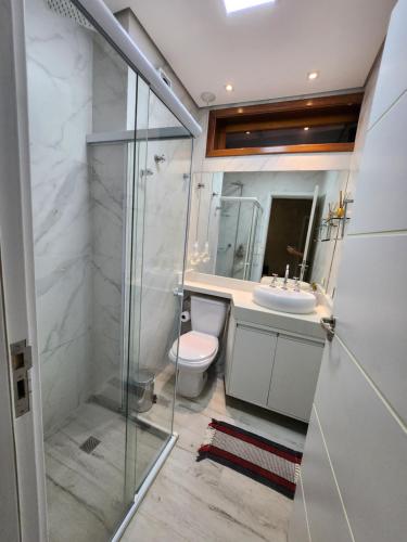 un bagno con doccia, WC e lavandino di Maresias Beach Home - Mata Azul a Maresias