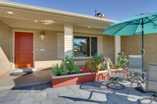 a house with a patio with a table and an umbrella at Modern Wheat Ridge Home with Private Hot Tub and Sauna in Wheat Ridge
