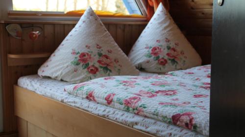 ein Bett mit zwei Kissen und einem Fenster in der Unterkunft Ferienhof Marlin - Ferienhaus Rügen in Solkendorf