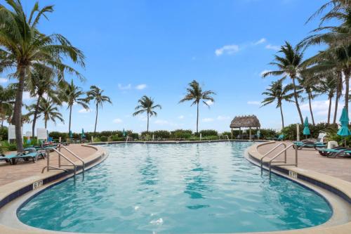 a pool at a resort with palm trees at Tides on Hollywood Beach in Hollywood