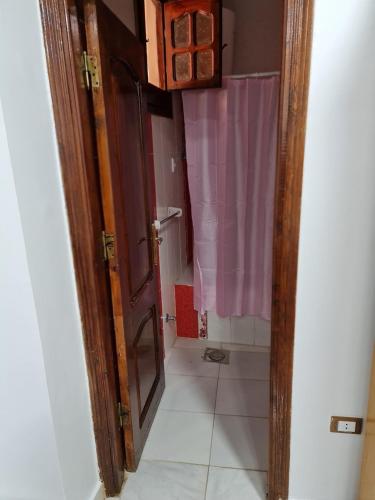 a bathroom with a door open to a pink shower at Happy pyramids inn Hotel in Cairo