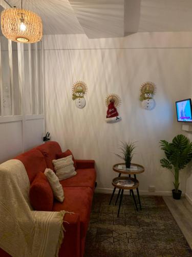 sala de estar con sofá rojo y mesa en Paris Jolie studio cosy en París