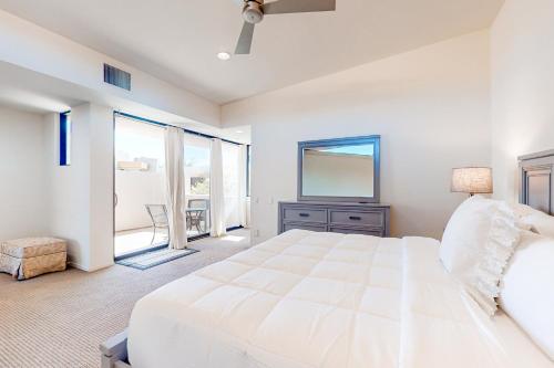 a white bedroom with a large bed and a window at Thai Palomino in Palm Springs