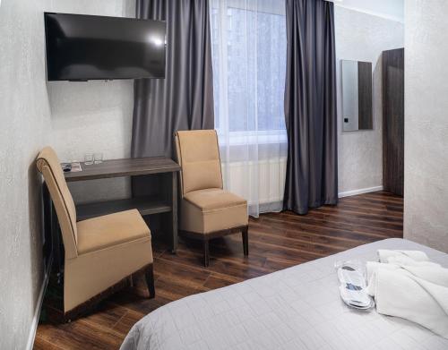 ヴィーンヌィツャにあるSafari-Clubのベッド、デスク、椅子が備わるホテルルームです。