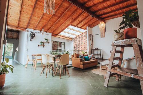 sala de estar con techo de madera, mesa y sillas en Centro Hostel Medellin, en Medellín