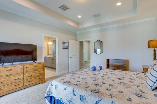 a bedroom with a bed and a dresser and a television at Modern Redington Beach Townhome Steps to Beach! in St Pete Beach
