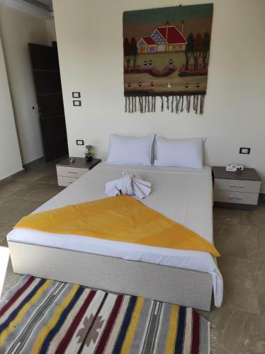 a bedroom with a bed with a yellow blanket on it at pyramids view suite/vista piramidi in Cairo