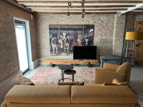 a living room with a couch and a flat screen tv at Landloft Haus Probst in Schondorf am Ammersee