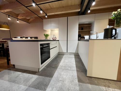 an open kitchen with white cabinets and a stove at Landloft Haus Probst in Schondorf am Ammersee