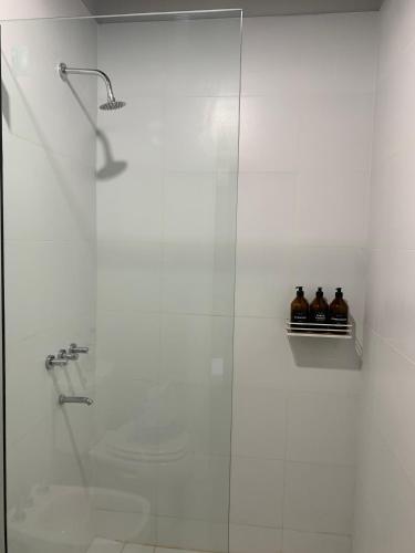 a bathroom with a shower with three bottles on a shelf at Bosques de Mayo Departamento 4 in Maipú