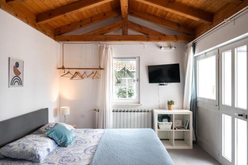 Schlafzimmer mit einem Bett und einem TV in der Unterkunft New cosy apartments with private parking in Opatija