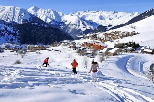 un grupo de personas esquiando por una montaña cubierta de nieve en Appart - Chalet du Hameau des Aiguilles, en Albiez-Montrond
