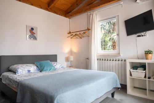 a bedroom with a bed and a tv on the wall at New cosy apartments with private parking in Opatija