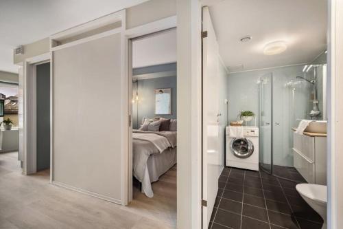 a bedroom with a bed and a bathroom with a washing machine at New Couples Apartment In the Heart of Bergen in Bergen