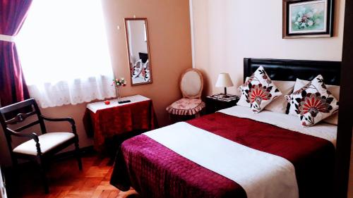 - une chambre avec un lit, une chaise et un miroir dans l'établissement the scandinavian, à Valparaíso