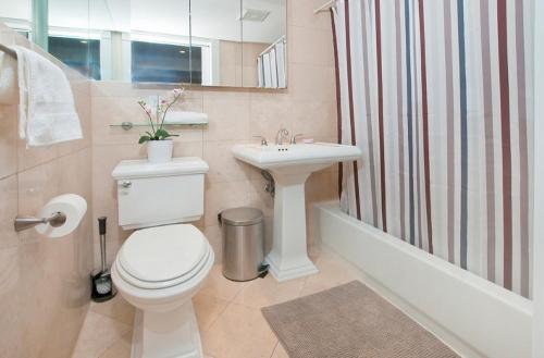 e bagno con servizi igienici, lavandino e doccia. di Modern 3BR Apartment in NYC a New York