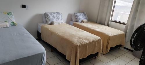 Zimmer mit 2 Betten, Decken und einem Fenster in der Unterkunft Quarto privativo WC compartilhado in Joinville