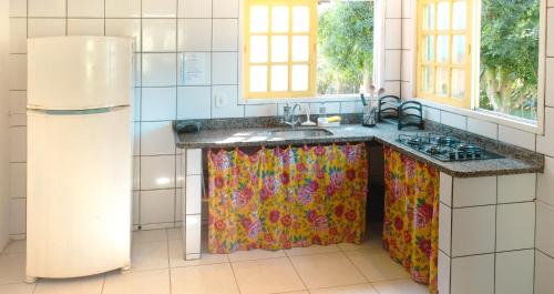 cocina con fregadero y nevera en Canto do Mar - Apartamentos e Casa com vista pro Mar - Cumuruxatiba en Cumuruxatiba