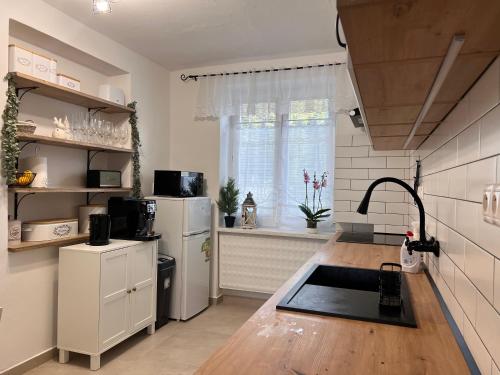 uma cozinha com um frigorífico branco e um lavatório em Izba “Jakub” em Martin