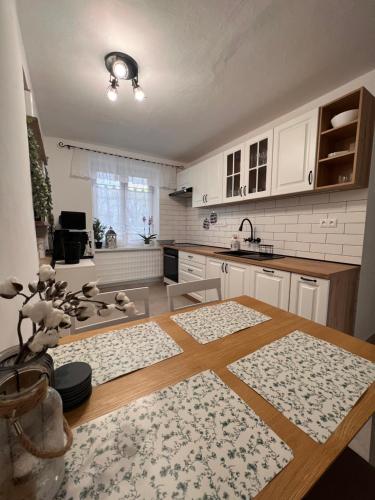 uma cozinha com armários brancos e uma mesa de madeira em Izba “Jakub” em Martin