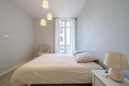 ein weißes Schlafzimmer mit einem Bett und einem Fenster in der Unterkunft Vidal Croisette in Cannes