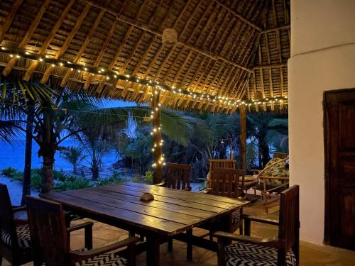 a wooden table with lights on a patio at Ocean Dream Villa in Ushongo Mabaoni