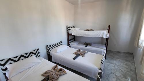 a room with three bunk beds with bows on them at Tamboleiros Hotel & Hostel in Salvador