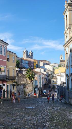 a group of people walking down a street with buildings at Tamboleiros Hotel & Hostel in Salvador