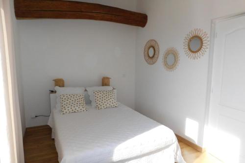 a bedroom with a white bed with two mirrors on the wall at Gite des Perrines 