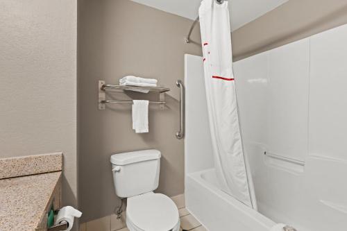 a small bathroom with a toilet and a shower at Red Roof Inn & Suites Newnan in Newnan