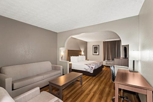 a hotel room with a bed and a couch at Red Roof Inn & Suites Newnan in Newnan