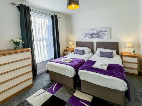 a bedroom with two beds and a window at 3 Bedroom House - Home away from Home - Sleeps 7 in Portsmouth