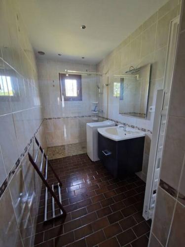 une salle de bain avec une baignoire, un lavabo et un miroir dans l'établissement Maison 3 chambres, à Commentry