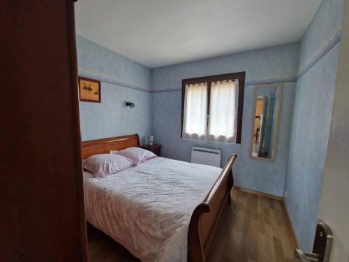 a bedroom with a bed with blue walls and a window at Maison 3 chambres in Commentry