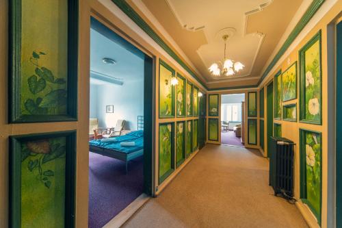 a hallway with paintings on the walls at Hotel Krasnoludki in Sosnówka