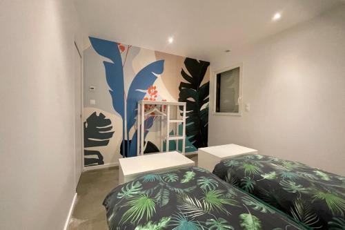 Zimmer mit 2 Betten und Wandgemälde in der Unterkunft Loft dans chaumière pour 6 personnes à SaintAndré in Saint-André-des-Eaux