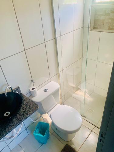 a bathroom with a toilet and a glass shower at Pousada Estrela Veadeiros in Alto Paraíso de Goiás