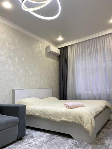 um quarto com uma cama e uma janela grande em ЖК Керемет em Karaganda