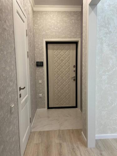 um corredor com uma porta num quarto em ЖК Керемет em Karaganda