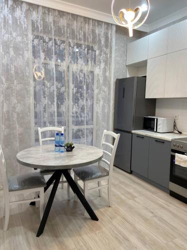 uma cozinha com mesa e cadeiras num quarto em ЖК Керемет em Karaganda