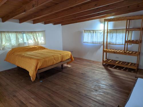 een slaapkamer met een bed en een houten vloer bij Casa Lidia in Chascomús