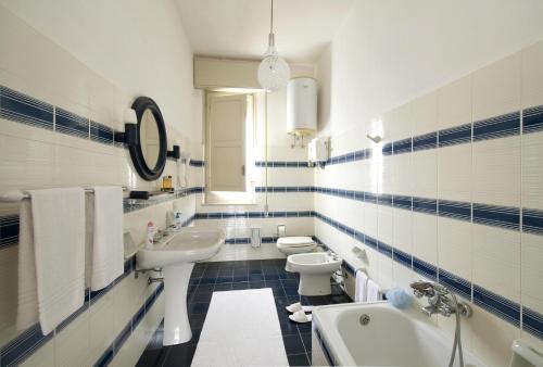 baño azul y blanco con 2 aseos y lavamanos en Villa Paradiso, en Castelluzzo