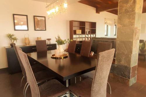 a dining room with a black table and chairs at Casa Vacacional en plena naturaleza 8 P. in La Esperanza