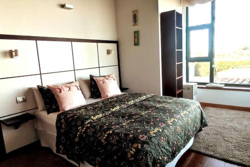 Un dormitorio con una cama con almohadas rosas y una ventana en Casa Vacacional en plena naturaleza 8 P., en La Esperanza