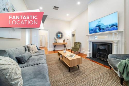 a living room with a couch and a fireplace at Waratah Cottage 1910 - Boutique in Glenunga