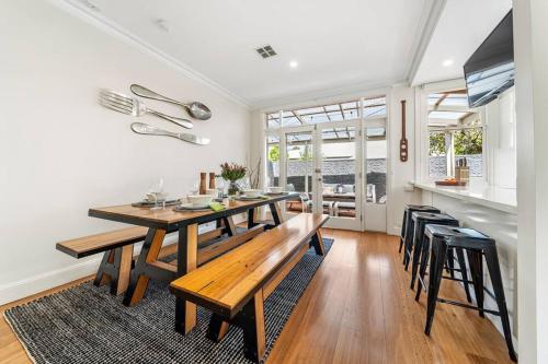 a kitchen and dining room with a wooden table and chairs at Waratah Cottage 1910 - Boutique in Glenunga
